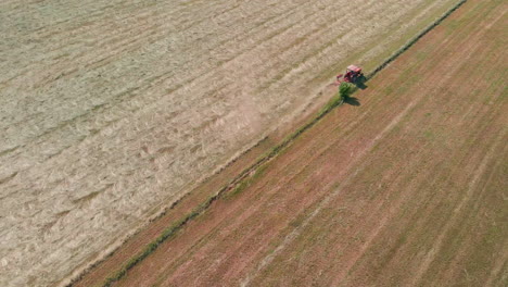 Roter-Traktor-Mit-Rechen,-Der-Im-Sommer-In-Norditalien-An-Frisch-Geschnittenen-Heuballen-Arbeitet