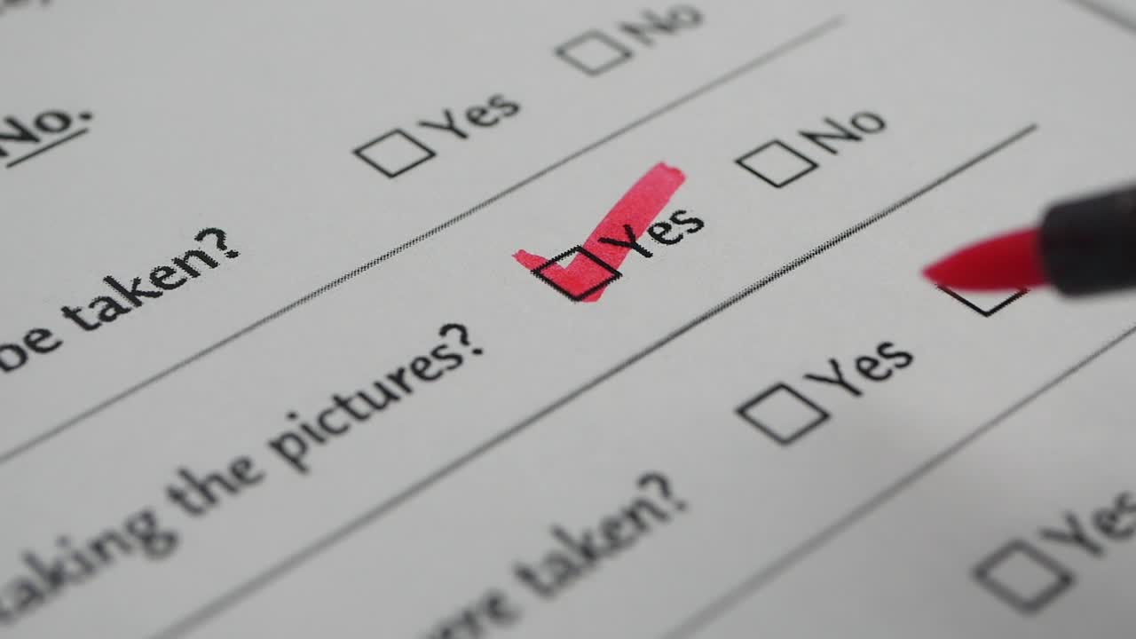 Red Marker Checking Yes and No Boxes on a Paper Form