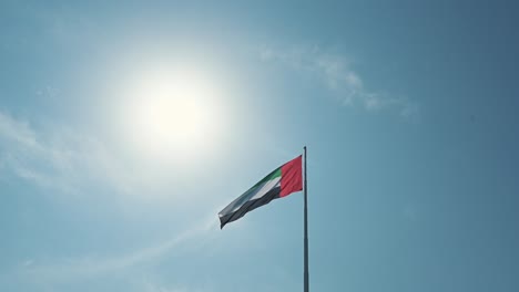 a bandeira dos emirados árabes unidos ondula em um mastro gigante de 122 metros de altura em abu dhabi, emirados árabes unidos