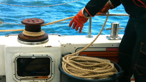 fisherman tying rope on bollard