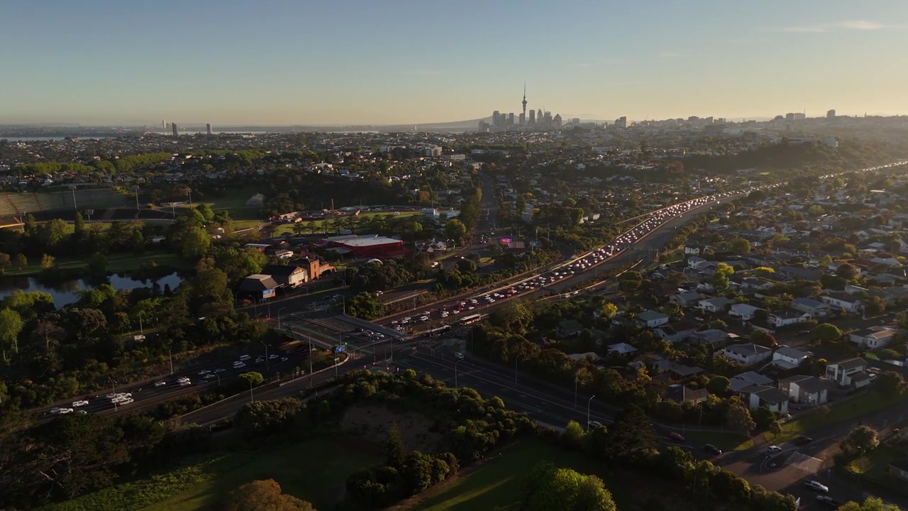 Traffico autostradale che confluisce nel centro di Auckland all'alba ad Auckland, Nuova Zelanda. Ripresa aerea con drone, paesaggio urbano.