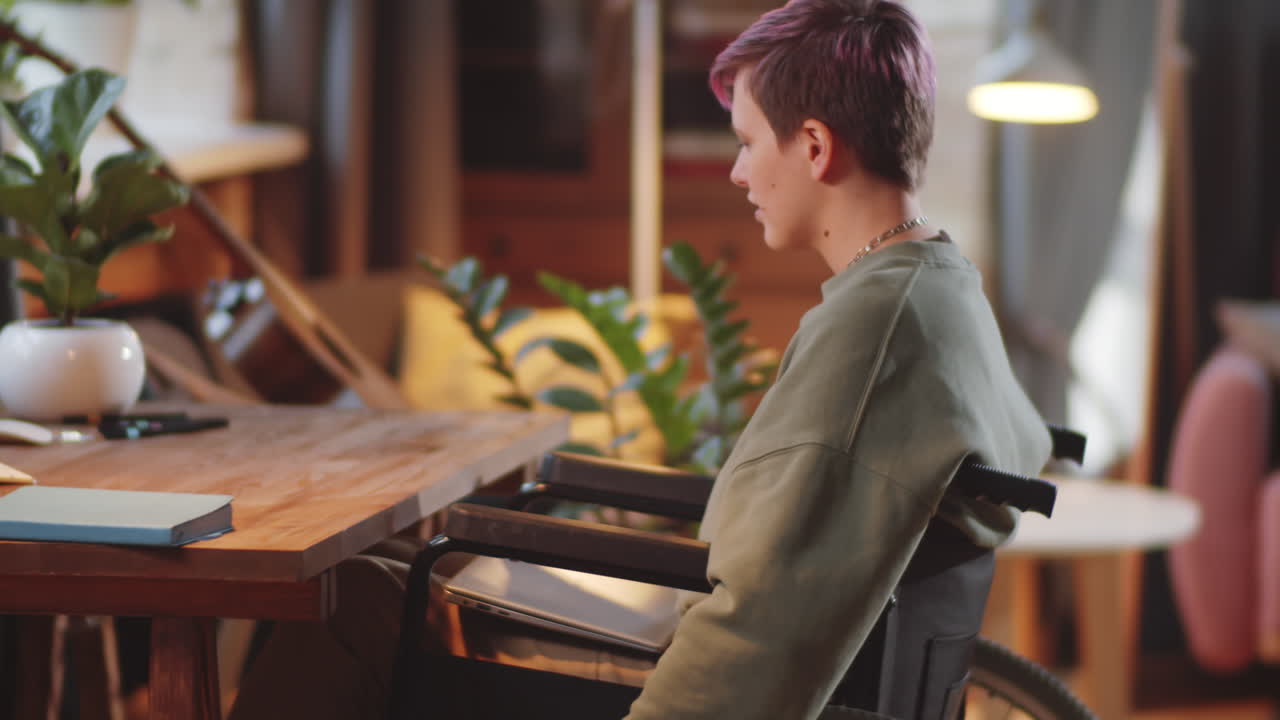 joven en silla de ruedas trabajando en una computadora portátil