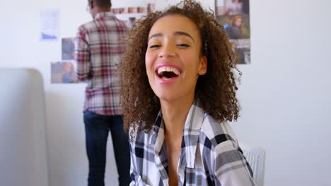 pretty mixed-race female executive smiling at desk in modern office 4k