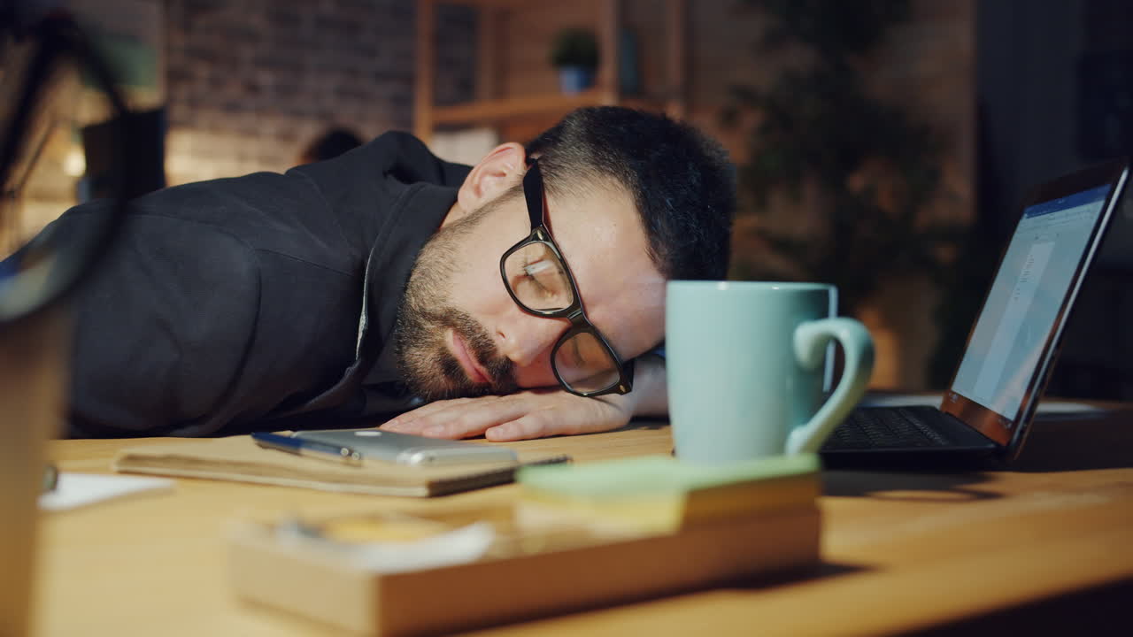 un uomo d'affari stanco che dorme alla scrivania.