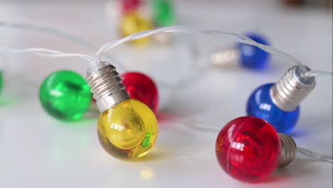 in close proximity, christmas led lights in blue, red, yellow, and green are visible against a white surface