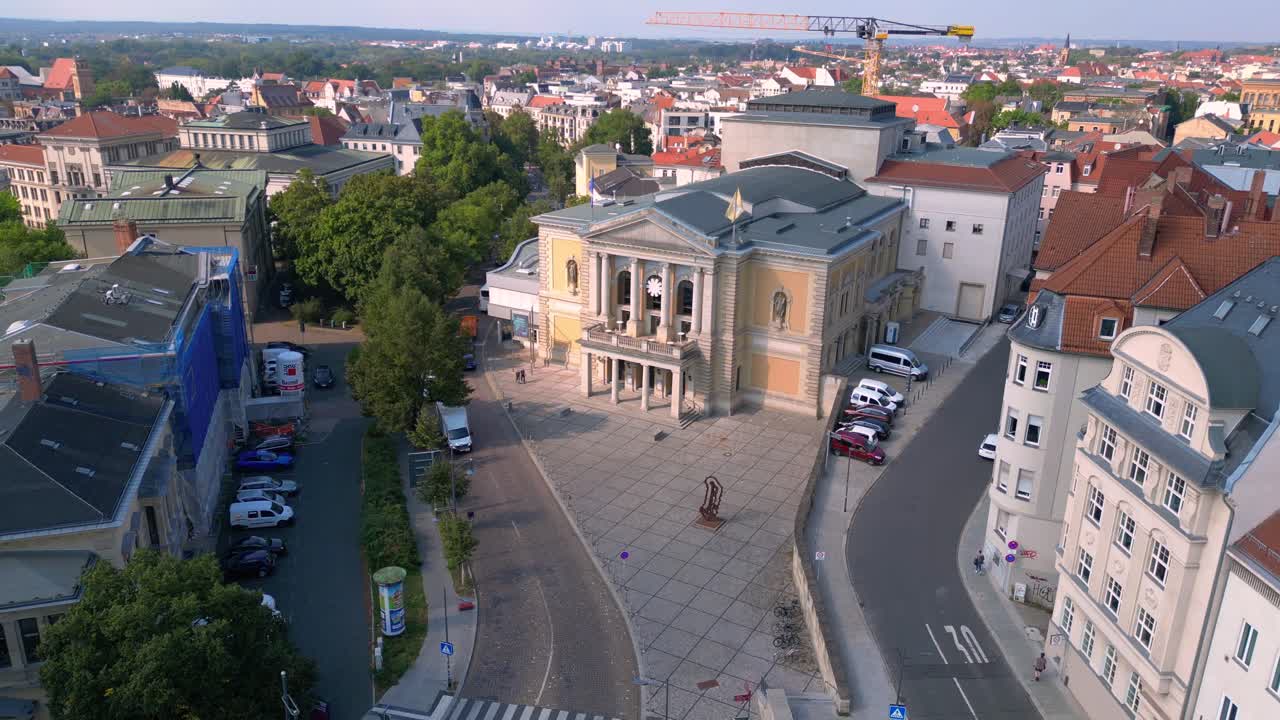 Fountains are cascading in front of the opera house on a sunny day in halle saale, germany. Majestic aerial view flight