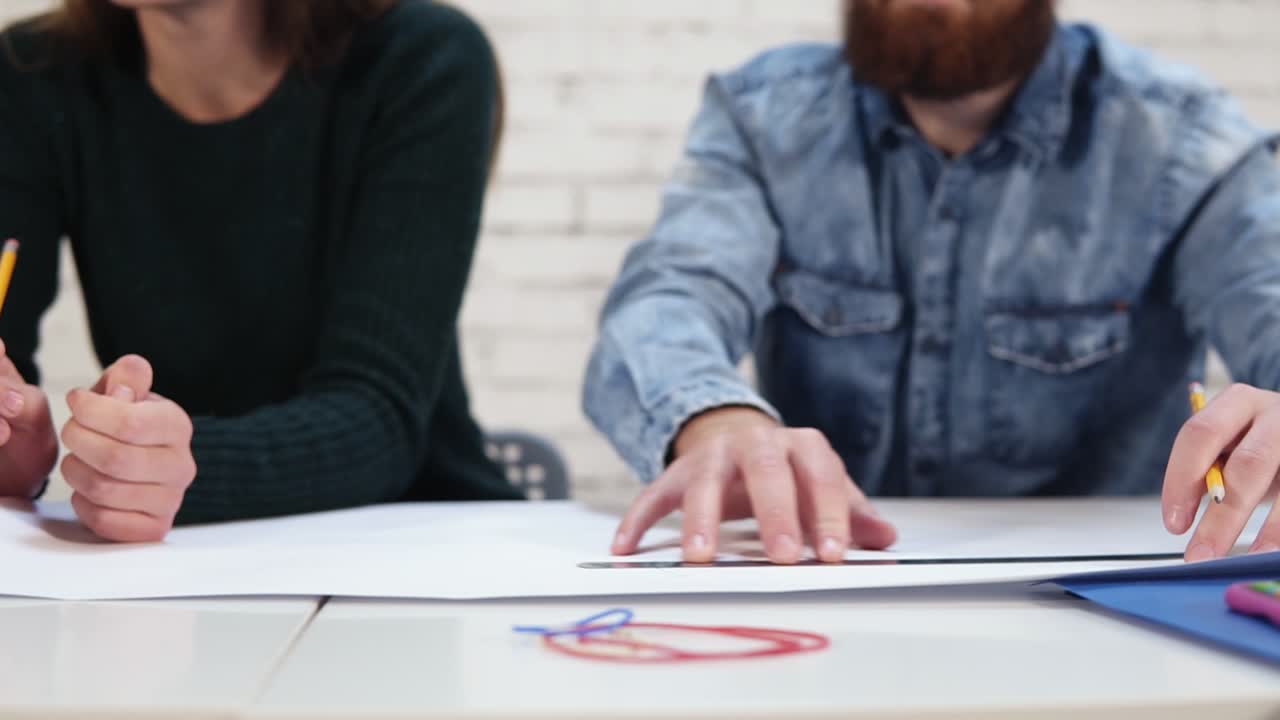 라운드 카메라 움직임: 행복한 다양한 그룹의 동료들이 현대적인 사무실에서 프로젝트를 진행하고 있습니다. 그들은 프로젝트를 사용하여 그림을 그리고 있습니다.