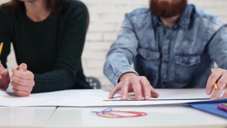 movimiento de la cámara redonda: feliz grupo diverso de colegas que trabajan en un proyecto en una oficina moderna: están dibujando un proyecto utilizando