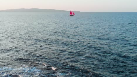 toma aérea por drones despegando de los acantilados de la costa filmando un barco lejos en el mar