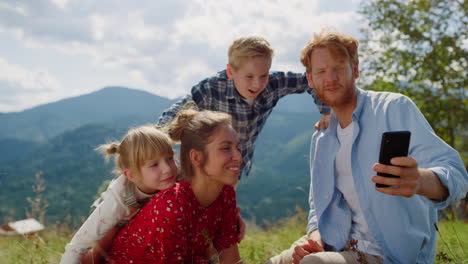 Family-using-smartphone-photo-in-mountains-close-up.-Parents-have-fun-with-kids.