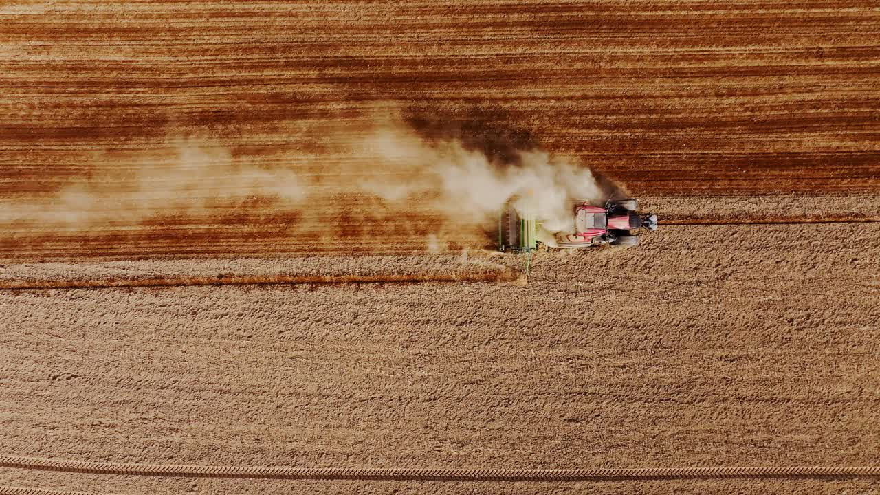 Strong spring wind lifts dry dust from brown field under Baltic golden sunset