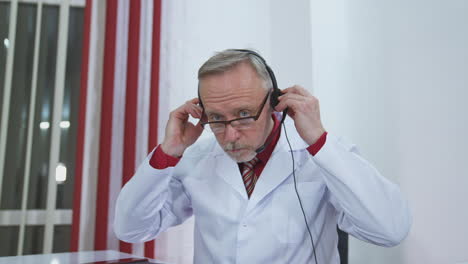 telemedicine. doctor putting on headphones and starting talking to a microphone during online consultation in medical center.