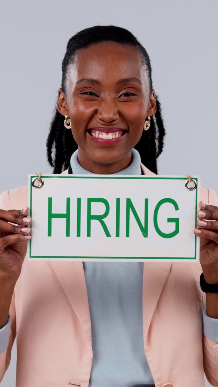 Smiling Woman Holding a Hiring Sign