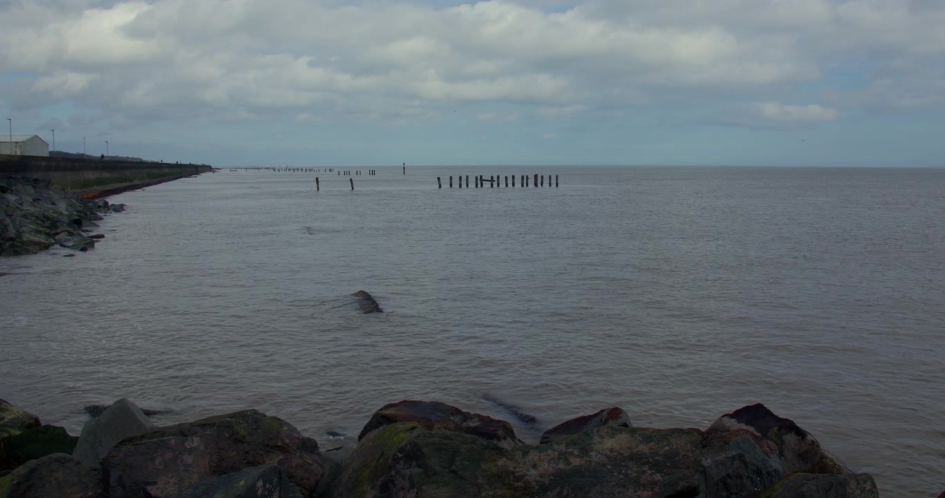 Ekstra bredt skud, der kigger nordpå langs Corton Strand med ødelagte høfder og sten i forgrunden ved Lowestoft
