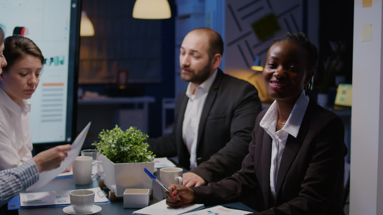 Portrait of focused african american woman writing investment strategy on notebook working overtime