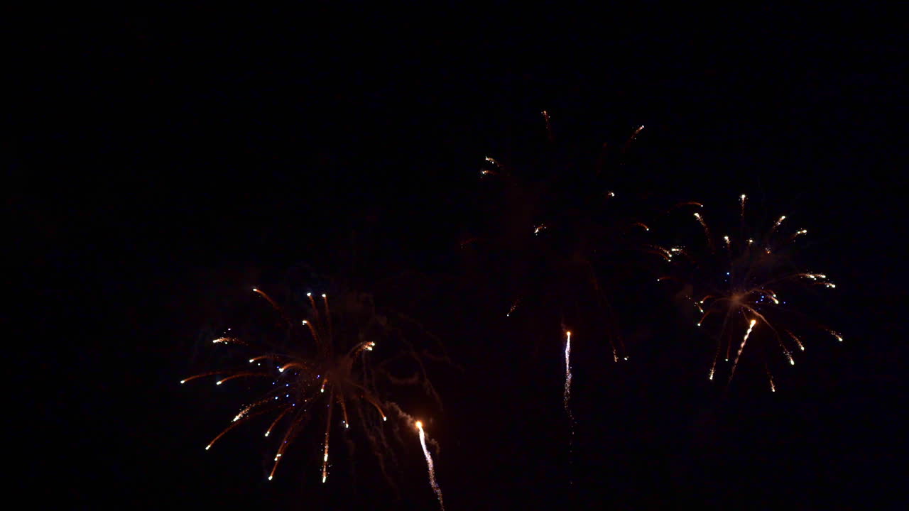 Groups of three mag stars fireworks explode in the night sky one after another