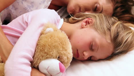 Mother-and-daughter-sleeping-together-in-bed