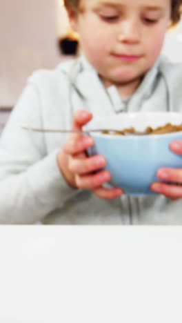 niño tomando el desayuno en la cocina