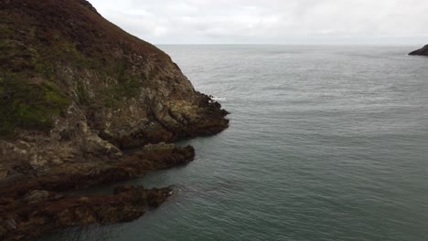 Schöne-Felsformation-In-Ruhigem-Wasser,-Traeth-Porth-Wen,-Vereinigtes-Königreich