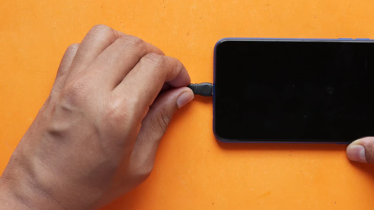 Mano che collega il cavo USB allo smartphone