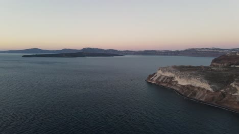 flying over the volcanic caldera of santorini during sunset