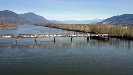 rail bridge crossing the fraser river in mission, british columbia, canada - aerial drone shot