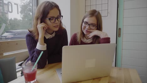 dos chicas estudiando en un café