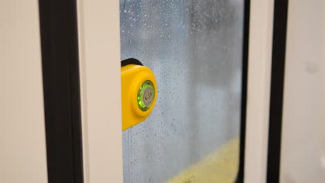 close-up of a yellow door handle on a train