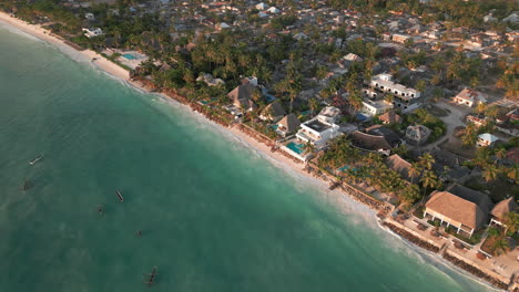 Drone-view-of-tropical-coastline-with-boats,-Zanzibar,-Paje
