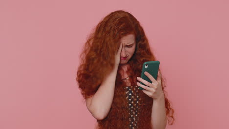 unhappy redhead woman use smartphone surprised by lottery results, bad fortune, loss, unlucky news