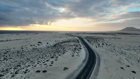 Eine-Straße-Inmitten-Von-Sanddünen-In-Fuerteventura