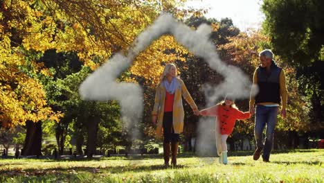 Smoke-forming-a-house-shape-against-caucasian-family-holding-hands-walking-in-the-park