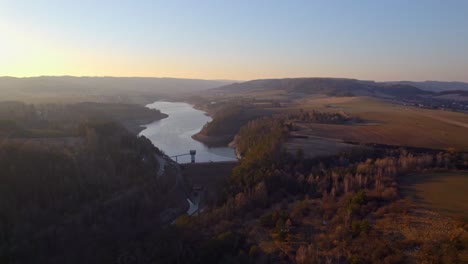 Drone-Aéreo-Sobre-Valle-Tranquilo-Con-Depósito-De-Agua-Kretinka-En-República-Checa-Al-Amanecer