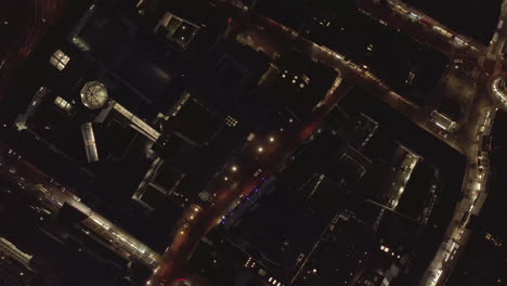 AERIAL:-Slow-Overhead-Shot-of-City-at-Night-with-Lights-and-Traffic,-Cologne,-Germany