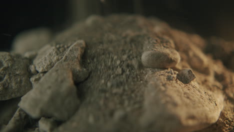 closeup shot of small sand grains and rocks falling and sliding on pile macro slider dolly shot