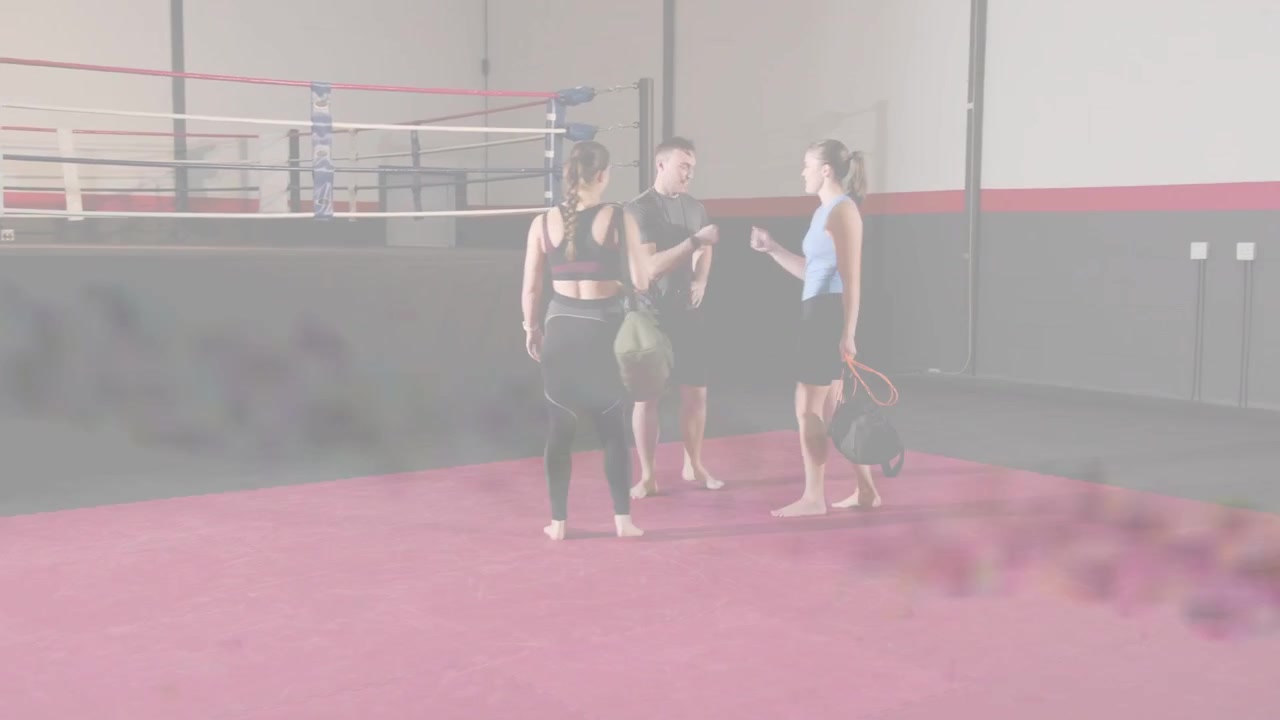 Duas mulheres entrando e caminhando pelo tatame de boxe até o treinador para o treino, com uma sobreposição de RA aparecendo ao redor do treinador.