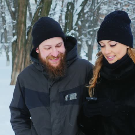 friends walking and using smartphone in wintery scene