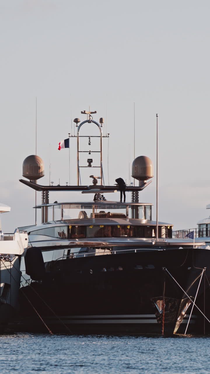 View of a man working on a boat docked in the Port de Cannes in France. Vertical