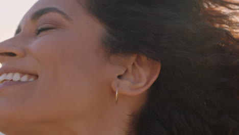 retrato en primer plano de una hermosa mujer feliz disfrutando de la libertad explorando la espiritualidad sintiendo alegría en una playa pacífica al atardecer con el pelo soplado por el viento