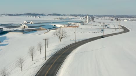 car on curvy road through winter snow landscape