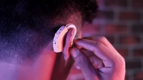 person adjusting hearing aid