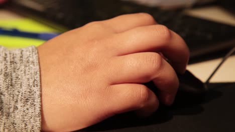 student's hand on a computer mouse