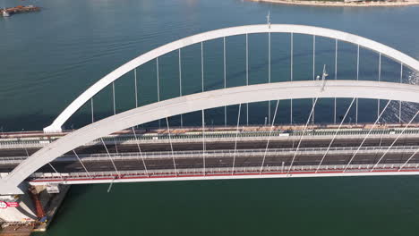 Aerial-tilt-down-approaching-shot-of-new-Cross-Bay-Link-bridge-with-pedestrian-traffic-near-Tsuen-Kwan-O-district-in-Hong-Kong