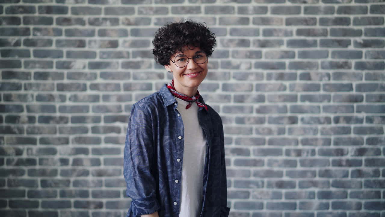 Woman Smiling in Front of a Brick Wall