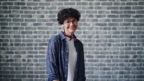 woman smiling in front of a brick wall