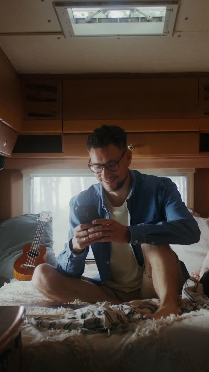 Uomo che usa il telefono in un camper
