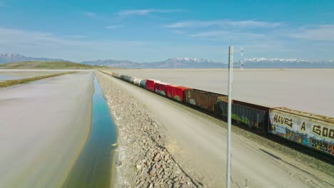 aerial - train on railway, great salt lake, utah, forward truck right shot