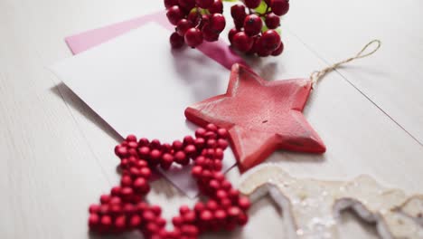 video of christmas decorations with white card on wooden background