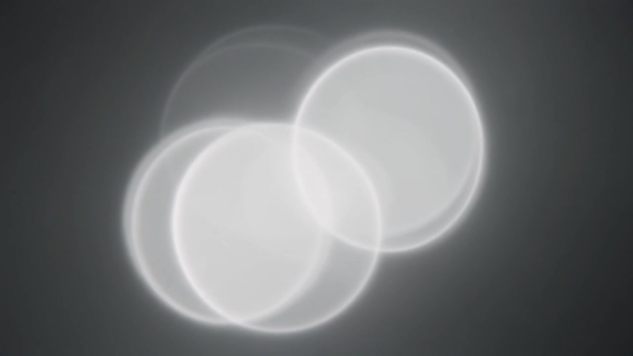 Abstract Motion of Glowing White Circles on Dark Background