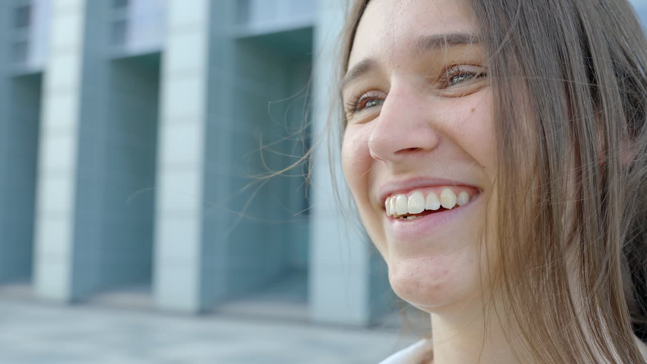 primer plano de una señora sonriente frente al edificio de oficinas